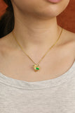 Close-up of a woman wearing a natural Burmese jade bird pendant with green jade and gold details. A handcrafted Lucky Songbird necklace styled for everyday wear.